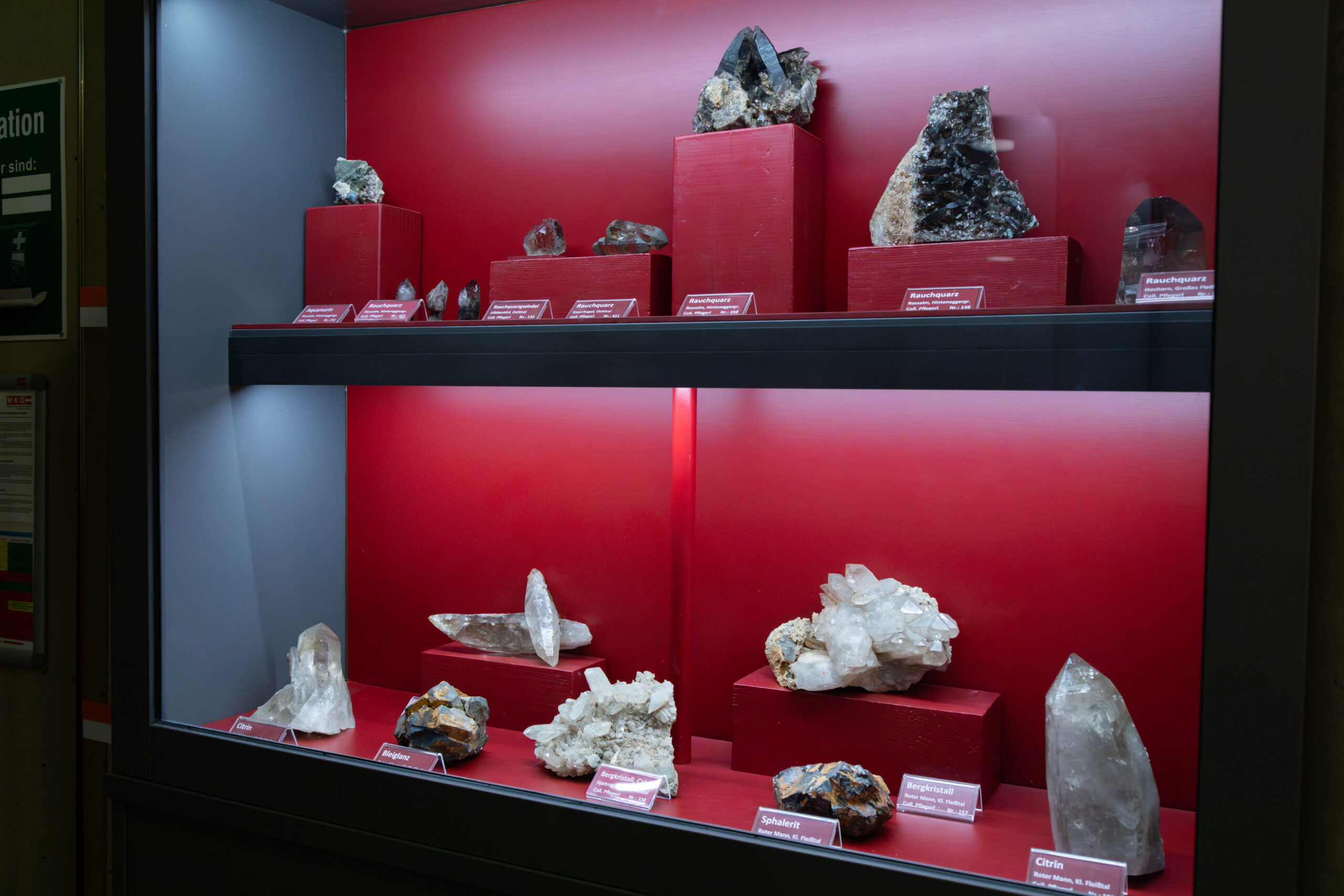 Ein Bild vom Kristallaustellung. Verschiedene Kristallen sind im Vitrine dargestellt.